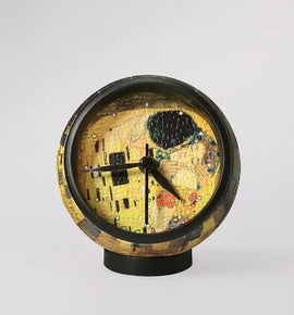 A unique 3D jigsaw puzzle clock featuring Gustav Klimt's iconic artwork 'The Kiss'. The clock has a round shape, showcasing vibrant colors and intricate details from the painting, mounted on a sturdy base. The clock hands are clearly visible against the artwork, making it a perfect blend of art and functionality.