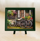 A beautifully framed jigsaw puzzle featuring a picturesque scene of bicycles parked on a charming street in Amsterdam, adorned with colorful flowers and a rustic doorway. The 150-piece puzzle is perfect for cycling enthusiasts and puzzle lovers alike, showcasing the vibrant culture of the Netherlands.