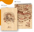 Front and back view of the Love Corner A5 Jigsaw Notebook Cover + Notebook by Pintoo. The front features a window scene with a plant and scattered items, while the back shows a charming café illustration with outdoor seating, inviting a creative atmosphere for journaling.