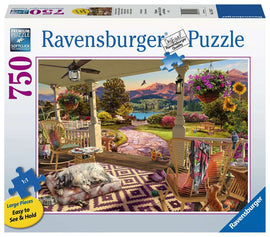 A cozy front porch scene depicted in a 750-piece jigsaw puzzle by Ravensburger. The image features a beautifully landscaped exterior with vibrant flowers, a picturesque pathway, and comfortable rocking chairs. A sleepy dog lies on a rug while a playful kitten sits nearby, inviting relaxation in this serene setting. Perfect for puzzle enthusiasts looking to create a charming outdoor scene.