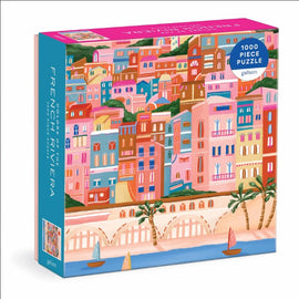 Colors Of The French Riviera jigsaw puzzle by Galison featuring a vibrant, illustrated coastal scene with colorful buildings and palm trees. The puzzle consists of 1000 pieces, designed for both fun and a delightful challenge.