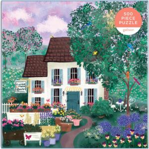 A colorful jigsaw puzzle titled 'Garden Path' by Joy Laforme, featuring a charming house surrounded by lush greenery and vibrant flower pots. The puzzle consists of 500 pieces and showcases a picturesque garden setting.