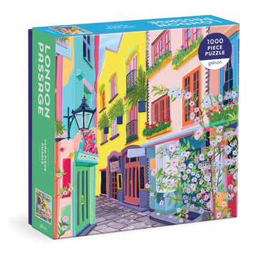 The London Passage jigsaw puzzle by Galison features a vibrant, colorful scene of a charming street lined with blooming flowers and beautifully painted buildings. The puzzle consists of 1000 pieces and showcases intricate details, making it a delightful challenge for puzzle enthusiasts.