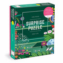 A colorful jigsaw puzzle box titled 'Shelf Life Surprise Puzzle' by Galison, featuring a vibrant design with flowers and gardening themes. The box contains 1000 pieces and has a sticker that says 'Watch the scene emerge as you complete the puzzle!'