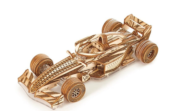 A detailed wooden model of a Formula racing car, showcasing intricate laser-cut designs. The model features realistic wheels, a sleek body, and a driver seat, all crafted from pale wood. Perfect for display or DIY enthusiasts.