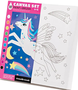 Crocodile Creek Canvas Art DIY kit featuring a whimsical unicorn illustration. The set includes 10 acrylic paint tubes and two paintbrushes, offering a fun artistic experience for kids aged 6 and up. The canvas showcases a partially colored unicorn with stars and a rainbow, ready to be painted.