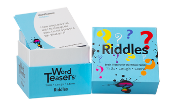 A box of Word Teasers Riddles featuring colorful question marks on the exterior. The top of the box displays the word 'Riddles' prominently, while a card peeks out, posing a riddle, 'I have wings and a tail and I fly through the skies. I'm not a bird or a bat. What am I?' Ideal for family fun, this game encourages talking, laughing, and learning.