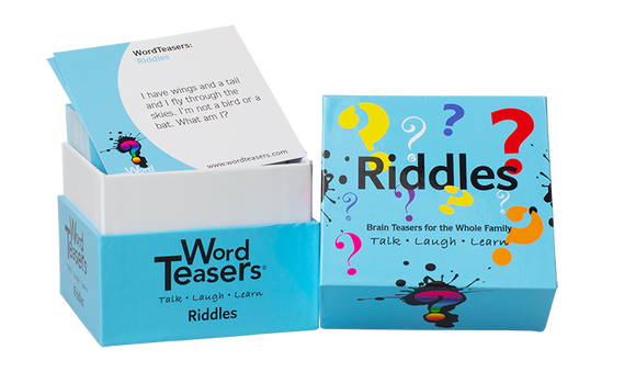 A box of Word Teasers Riddles featuring colorful question marks on the exterior. The top of the box displays the word 'Riddles' prominently, while a card peeks out, posing a riddle, 'I have wings and a tail and I fly through the skies. I'm not a bird or a bat. What am I?' Ideal for family fun, this game encourages talking, laughing, and learning.