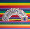 A vibrant display of DKNG Rainbow Wheels Playing Cards arranged in a fan shape, showcasing colorful card backs against a multi-colored striped background. The cards feature intricate designs, perfect for card games and collectors alike.