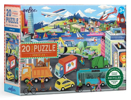 Eeboo's Vehicles 20 Piece Puzzle showcases a vibrant illustration of various vehicles including trucks, bikes, and airplanes, set against a colorful landscape of mountains, buildings, and water. Suitable for ages 3 and up, this eco-friendly puzzle features engaging artwork designed to stimulate children's imaginations and encourage problem-solving skills.