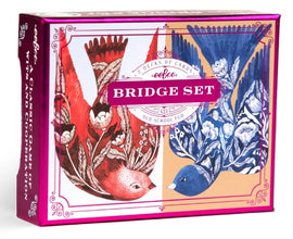 A vibrant and artistic box set of Bridge playing cards by Eeboo, featuring beautiful illustrations of colorful birds in red and blue tones, with floral designs. The packaging is elegantly pink and showcases the title 'Bridge Set' prominently.