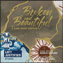 The game 'Broken and Beautiful' by Left Justified Studio features an elegant design with gold lettering. The box showcases the theme of Kintsugi, emphasizing beauty in brokenness, and includes icons indicating it is suitable for 2-4 players, ages 12 and up, and has a playtime of 15 minutes. The names of the game designer, Patrick Rauland, and illustrator, Shirley Gong, are noted on the box.