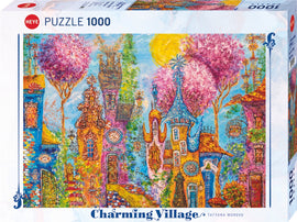 The Charming Village Pink Trees jigsaw puzzle by Heye features a vibrant, whimsical scene of colorful houses surrounded by blooming pink trees. The sun shines brightly in a clear blue sky, enhancing the enchanting atmosphere of the village.