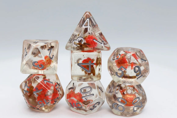 A colorful Flower Seed RPG Dice Set made by Foam Brain, featuring various shapes including a d20, d12, d10, d8, d6, and d4. The dice are translucent with embedded flower petals and clearly marked numbers, ideal for tabletop games or role-playing sessions.