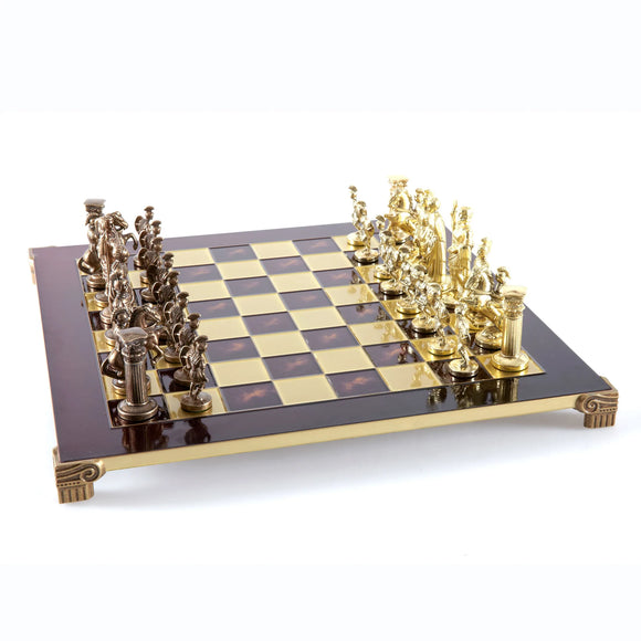 An elegant 11-inch brass and gold chess set featuring intricately designed Greek and Roman-style pieces. The chessboard has a glossy finish with alternating dark and light squares, perfect for classic gameplay.