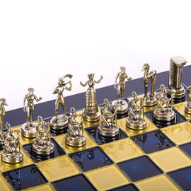A detailed view of a 15" Minoan Warrior Gold chess set by Manopoulous, featuring intricately designed golden pieces positioned on a black and yellow chessboard. The unique pieces represent Minoan warriors, showcasing their historical significance and artistic craftsmanship.