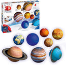 Ravensburger 3D Solar System Jigsaw Puzzle displaying nine colorful planet pieces, including Saturn, Jupiter, and Earth, with the puzzle box in the background. Each planet is represented as a 3D sphere, showcasing intricate details and vibrant colors, suitable for ages 6 to 99.
