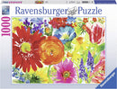 A colorful jigsaw puzzle box for the Ravensburger Abundant Blooms 1000 piece puzzle, featuring a vibrant floral design with various flowers like gerberas, tulips, and other blossoms in warm hues. The box displays the premium quality and soft-click technology of Ravensburger puzzles, ideal for puzzle enthusiasts.