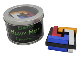 A colorful mechanical puzzle titled 'Heavy Metal: Whirlpool' by Eureka Puzzles. The puzzle is displayed outside its round metal tin, showcasing various geometric shaped blocks in metallic colors like blue, red, black, gold, silver, and white, all carefully arranged to challenge the player.
