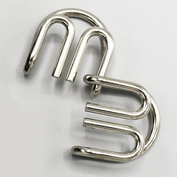 Double M Mechanical puzzle by Eureka Puzzles featuring two interlocking metal components. The design emphasizes intricate patterns and is crafted for engaging problem-solving.