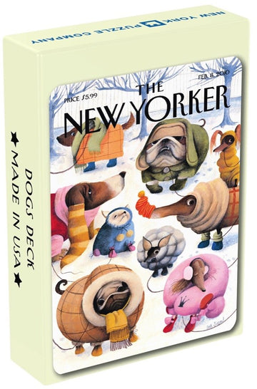 A playful illustration of various dog characters dressed in winter clothing, playing in the snow, featured on the packaging of Dog Cartoons Playing Cards by New York Puzzle Company.
