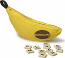 Bananagrams game displayed with a vibrant yellow banana-shaped pouch containing letter tiles. Some tiles are scattered around the pouch, showcasing the game pieces used for creating words.