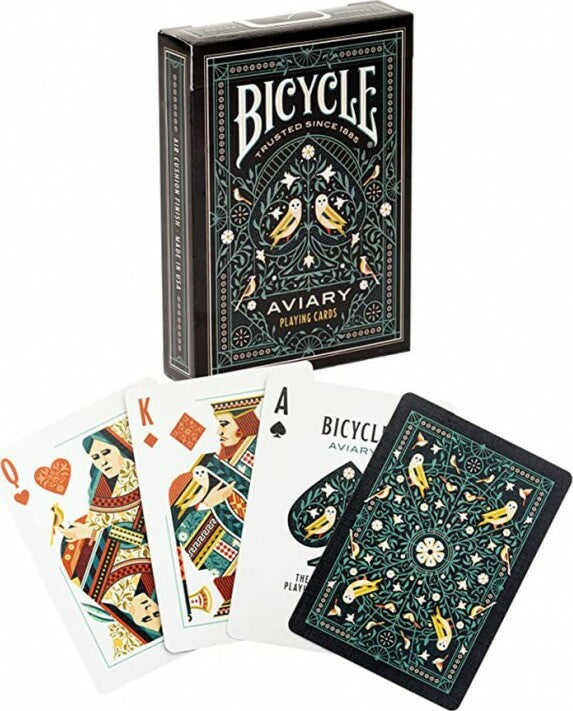 Bicycle Aviary playing cards featuring a beautifully illustrated deck with intricate designs including birds and floral patterns. The box is shown alongside several face cards including the Queen, King, and Ace, highlighting the artistic details.
