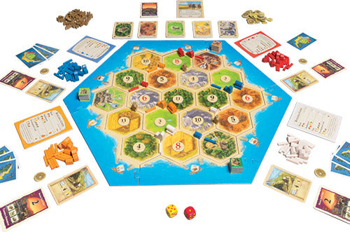 Catan: Traders & Barbarians game by Asmodee, featuring a colorful hexagonal board, player pieces in various colors, resource cards, development cards, and dice, set up for gameplay.