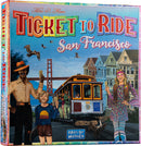 The box of the game 'Ticket to Ride: San Francisco' by Days of Wonder features vibrant artwork depicting iconic San Francisco landmarks, including the Golden Gate Bridge and colorful Victorian houses. Characters such as a boy, a man in a hat, and a woman in 1970s attire are shown celebrating the beauty of the city while a cable car rolls through the scene.
