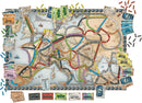 An illustrated board game design for Ticket to Ride: Europe, featuring a detailed map of Europe with colorful train routes connecting major cities. The game includes tokens and train cards in various colors, arranged along the edges, alongside destination tickets and illustrations depicting historical train designs.