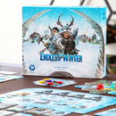 Endless Winter Paleoamericans board game by Fantasia Games, featuring striking artwork on the box depicting characters in winter attire. Game components like resource tokens and map tiles are visible on a wooden table, highlighting an engaging gaming experience.