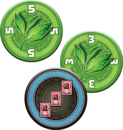 Close-up of game tokens from Jaipur (New Edition) by Space Cowboys, featuring circular tokens with green tea leaves and colorful illustrations of stamps, indicating points in the game. The tokens are designed for a fast-paced two-player card game focused on trade.
