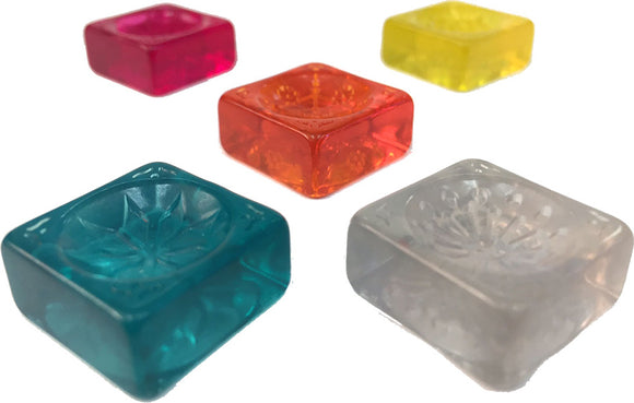 A vibrant image showcasing five colorful stained glass tiles used in the game Azul: Stained Glass of Sintra. The tiles feature intricate designs and come in various bright colors including teal, pink, orange, yellow, and clear. Perfect for board game enthusiasts.