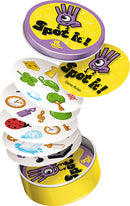 Spot it! Box by Zygomatic featuring a vibrant yellow tin. The game includes various round cards with colorful illustrations like a ladybug, clock, globe, and more, all stacked inside the open tin. The game is designed for fun observation and quick reflexes, making it enjoyable for players of all ages.