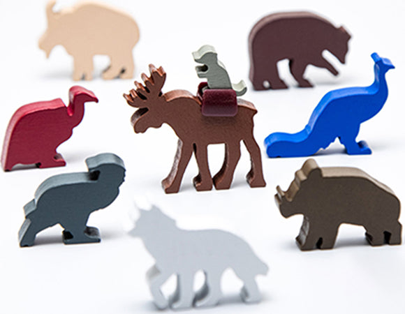 An assortment of colorful animal figures from the Everdell Spirecrest Expansion. Includes a moose with a rider, a blue dinosaur, and various other stylized animals in different colors, enhancing gameplay.