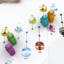 An overhead view of the Tokaido board game, showcasing colorful player pieces in green, purple, and orange on a beautifully illustrated game board. The board features vibrant landscapes and icons representing various destinations along the journey, suggesting a serene travel experience. The game emphasizes strategy and interaction in a visually appealing setup.