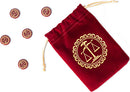 A red velvet pouch with a golden scale emblem holds game tokens featuring various designs related to the game Love Letter by Z-Man Games. The tokens are circular with distinct symbols and are scattered around the pouch, emphasizing the game's elegant aesthetic.