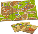 Carcassonne: Expansion 1 – Inns & Cathedrals game featuring colorful tiles depicting roads, towns, and landmarks. Includes scoring tiles for advanced gameplay.
