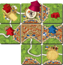 Carcassonne: Expansion 10 – Under the Big Top features colorful game tiles depicting a vibrant fairground scene with a circus tent and various meeples in red and blue. The board layout includes roads, towns, and fields, showcasing strategic placement opportunities for players as they expand their Carcassonne territory.