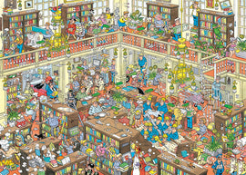A vibrant and detailed jigsaw puzzle titled 'The Library' by Jumbo, depicting a bustling library filled with diverse characters reading, working, and interacting. The scene showcases bookshelves lined with colorful books, tables with scattered papers and plants, and various activities happening throughout the multi-level space. Ideal for puzzle enthusiasts who enjoy intricate designs and lively settings.