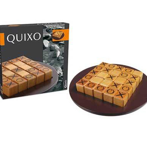 The Quixo game by Gigamic, featuring a wooden board with 25 square tiles displaying Xs and Os, arranged for strategic gameplay. The game's box is shown alongside the board, set against a neutral background, suggesting a focus on engaging game mechanics and visual appeal.