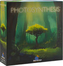 The box of the game 'Photosynthesis' by Blue Orange U.S.A. features a vibrant design showcasing a mystical forest scene with a luminous tree at its center, surrounded by lush greenery and dappled sunlight filtering through the trees, suggesting a theme of growth and nature.
