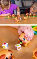 Two children joyfully playing the 'Tongues Out!' game by Blue Orange U.S.A. on a wooden table. One child is selecting a colorful dog figure while the other rolls dice. The game features cute, playful dog characters and a colorful playing board with a fun design.