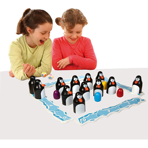 Two children joyfully playing the Pengoloo game by Blue Orange U.S.A. The game features colorful penguin pieces on a board. Each child is engaged, with one girl in a green shirt and the other in a pink shirt, as they interact with the game and its colorful components.
