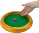 A circle wooden dice tray featuring a smooth wooden rim and a green felt surface. A hand is poised above the tray as a red die spins on the surface, highlighting its use in board games or tabletop gaming settings.