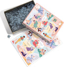 The Cobble Hill jigsaw puzzle titled 'Literary Women' showcases a colorful illustration of diverse women engaged in reading and various creative activities. The puzzle box is opened, revealing numerous pieces inside. An extra sheet with the completed design is displayed beside the box, capturing the vibrant artwork in shades of pink, green, and blue, along with artistic details of the women.