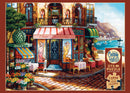 A colorful jigsaw puzzle titled 'Chez Michelle' by Cobble Hill, depicting a charming bistro scene. The artwork features vibrant flowers, outdoor seating, and picturesque buildings with a backdrop of mountains and a waterfront, ideal for puzzle lovers seeking a relaxing challenge. Contains 275 large pieces for easy handling, and a poster is included.