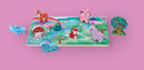 A colorful wooden jigsaw puzzle featuring a unicorn garden scene with various animal-shaped pieces. The puzzle board depicts a whimsical landscape with mushrooms, flowers, a rainbow, and a fox, surrounded by playful unicorns and a vibrant tree.