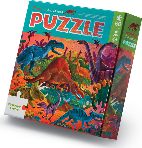 The Dazzling Dinosaurs Foil Puzzle by Crocodile Creek features a vibrant and colorful illustration of various dinosaurs set in a lush prehistoric landscape. The puzzle consists of 60 pieces, suitable for children aged 4 and up, emphasizing fun and educational play.