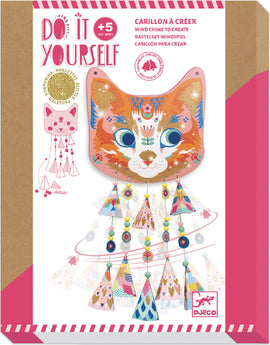 The Kitty Carillons Wind Chimes DIY kit from DJECO features a vibrant cat face design adorned with colorful patterns and glitter. The wind chime includes decorative elements like geometric shapes and playful beads, perfect for kids aged 5 and up to create a whimsical outdoor decor.